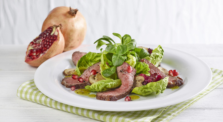 Blattsalat mit gebratenen Rindfleischstreifen und Granatapfel