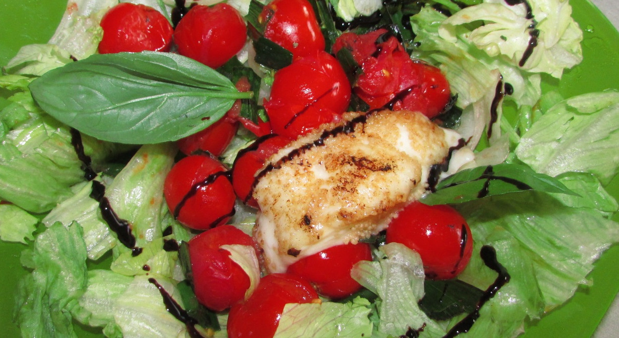 Panierte Mozzarella-Medaillons auf Eisbergsalat und Glasierte Cocktailtomaten